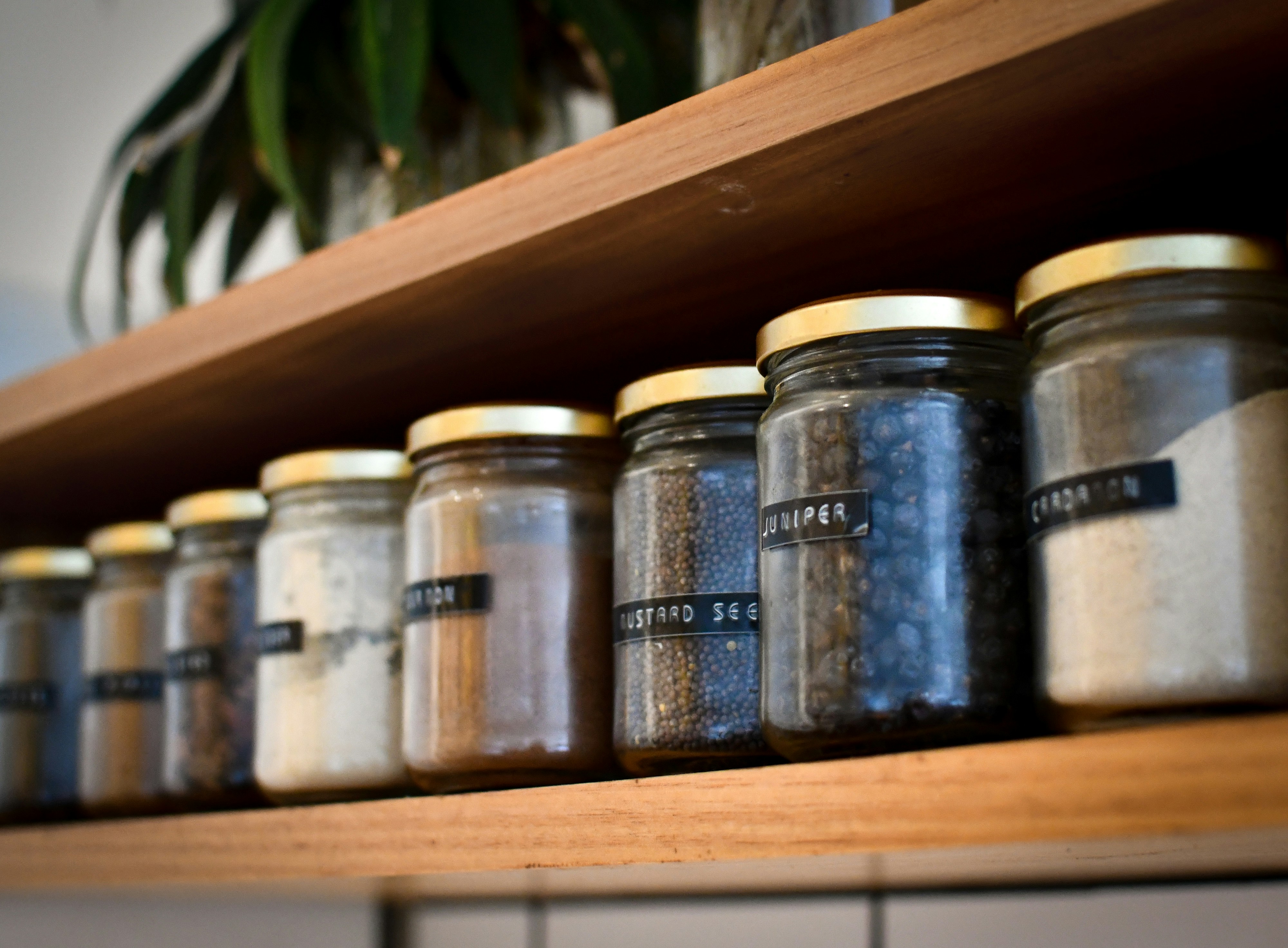 Glass jars, aluminium cans, and plastic bottles lined up on a kitchen counter
